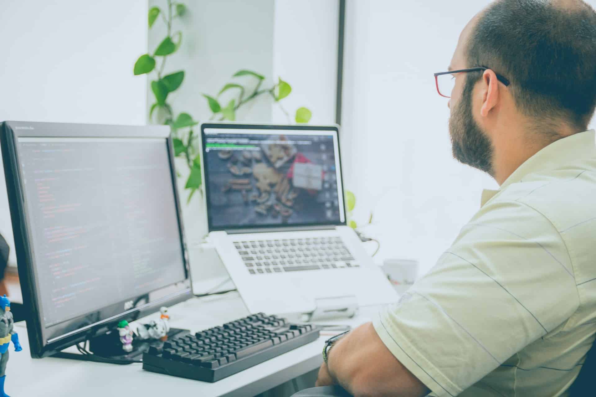 Technicien support analysant des incidents IT sur deux écrans